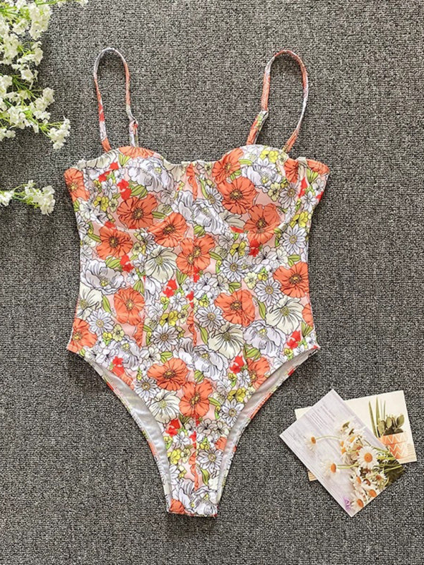 a floral print one piece swimsuit next to flowers