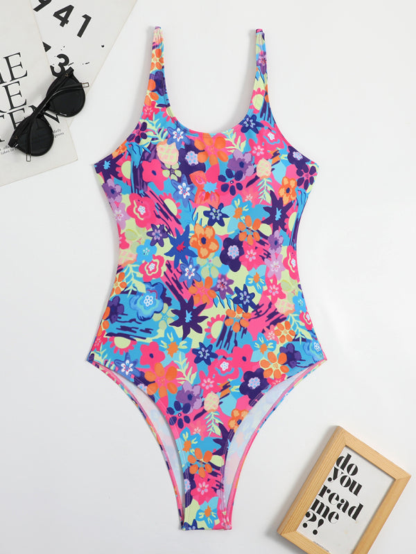 a colorful floral print swimsuit next to sunglasses