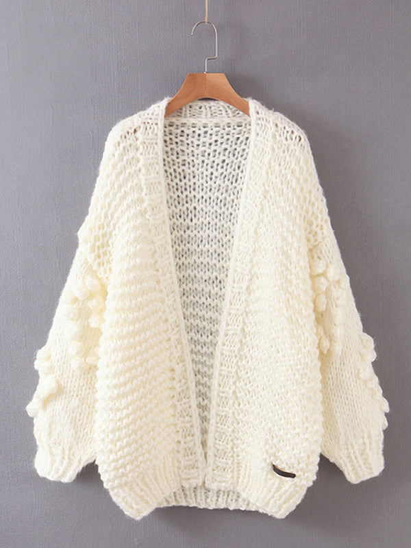 a white sweater hanging on a hanger