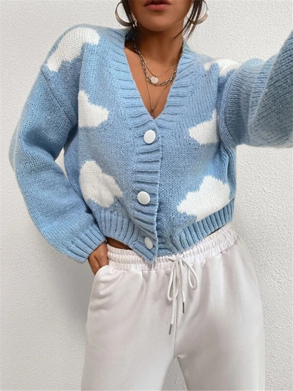 a woman wearing a blue sweater with white clouds on it