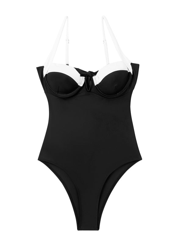 a woman wearing a black and white one piece swimsuit