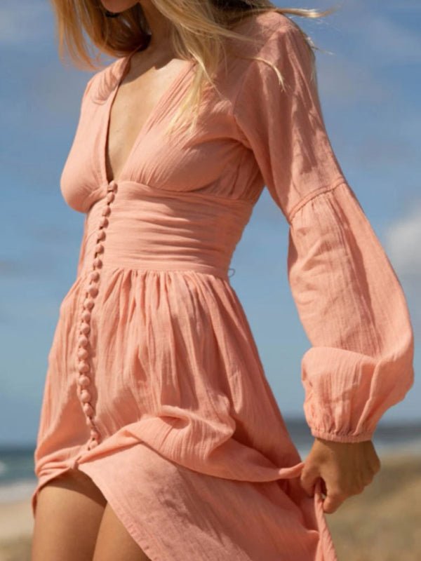 a woman in a pink dress on the beach