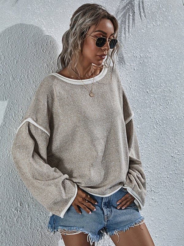 a woman wearing a grey sweater and ripped shorts