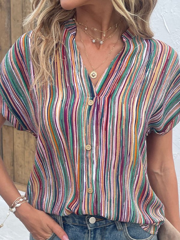 a woman wearing a colorful shirt and jeans