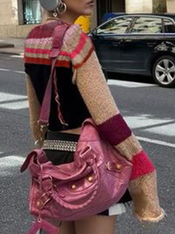 a woman walking down the street carrying a pink purse