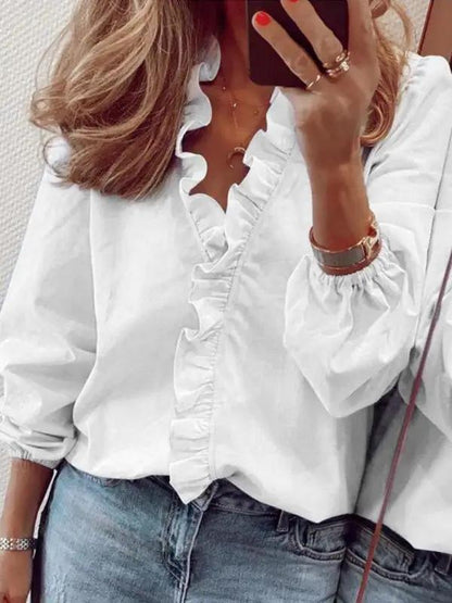 a woman wearing a white shirt and jeans talking on a cell phone