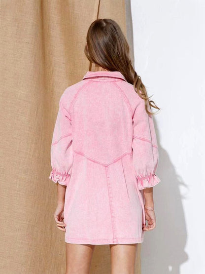 a little girl in a pink dress standing in front of a curtain