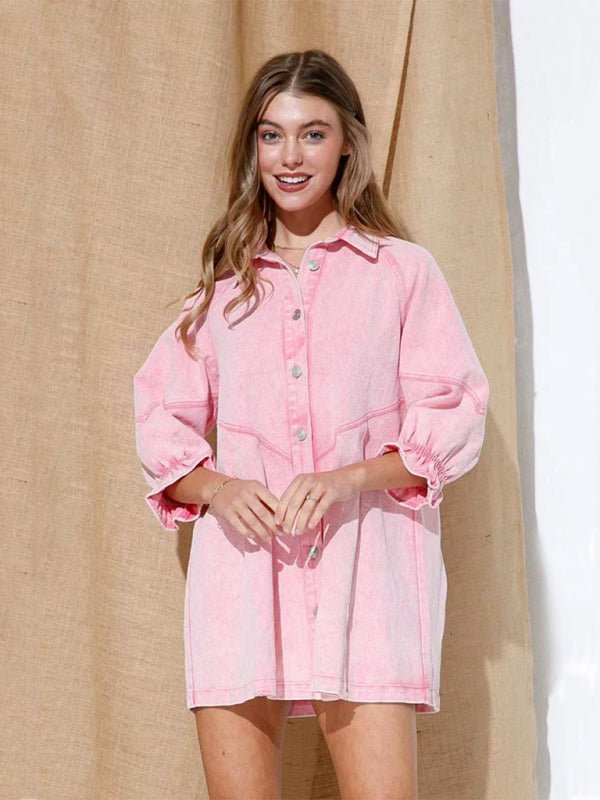 a woman in a pink shirt dress standing in front of a curtain