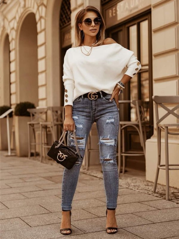 a woman wearing ripped jeans and a white sweater