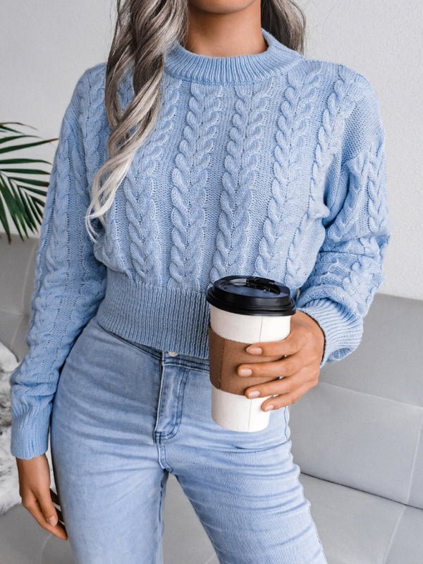 a woman wearing a blue sweater and jeans holding a cup of coffee