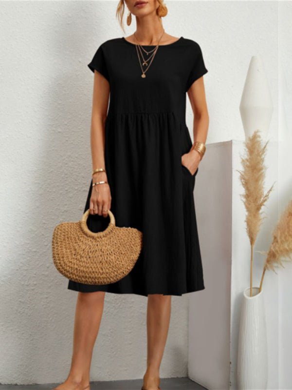 a woman in a black dress holding a straw bag