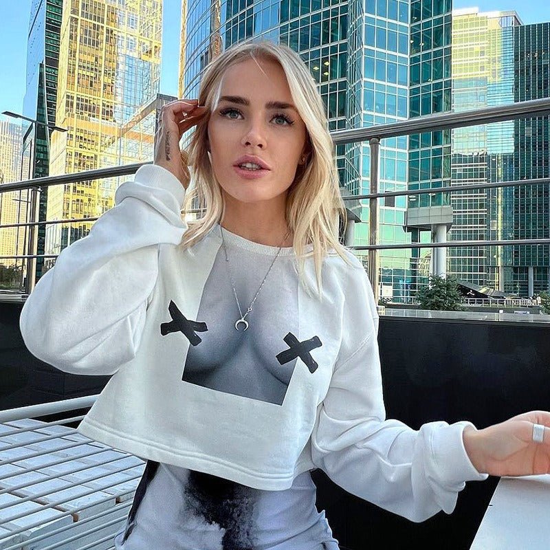 a woman sitting on a bench wearing a sweatshirt